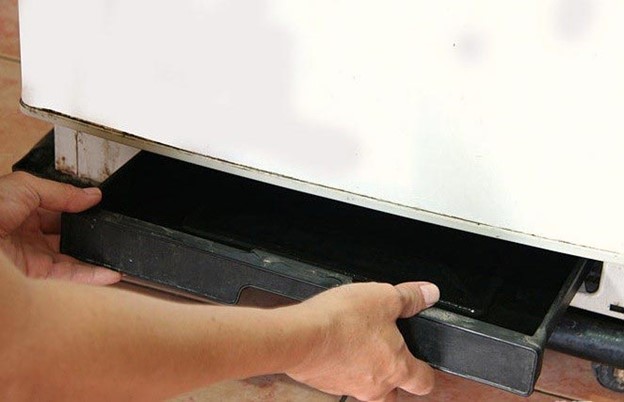 Repairing refrigerator leaking water by replacing the drain pan